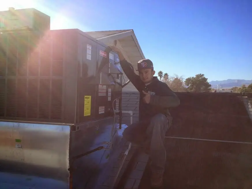 HVAC technician performing Heat Pump Repair on a rooftop unit in Florence